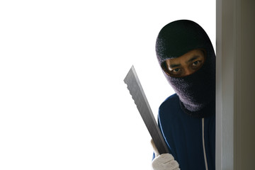 Masked robber with knife hiding behind the door