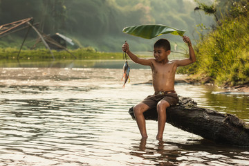 Little boy fishing in a river.