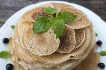 Green peppermint leaves are decorated with pancakes.