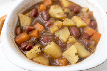 Appetizing beautiful soup with potatoes, onions, carrots and beans. close-up.