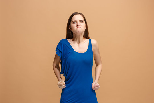 Portrait of an angry woman looking at camera isolated on a pastel background