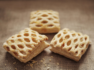 Three apple lattices on a hessian surface, crumbs in the foreground.