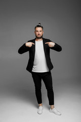 emotional man in a shirt with black hearts on a gray background
