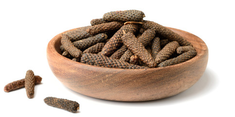 dried long pepper, piper longum in the wooden plate, isolated on white