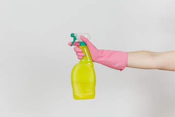 Close up of female hand in pink gloves click on yellow spray bottle with cleaner liquid with place for text isolated on white background. Cleaning supplies concept. Copy space for advertisement