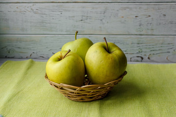 Small basket with fruits. Apples, lemons, carrot on the table. Jar of honey, bowl of oatmeal. Green tablecloth. Healthy eco lifestyle. Food blog illustrations. Cooking fruit salad. Pile of apples