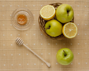 Small basket with fruits. Apples, lemons, carrot on the table. Jar of honey, bowl of oatmeal. Green tablecloth. Healthy eco lifestyle. Food blog illustrations. Cooking fruit salad. Pile of apples