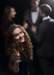 happy young woman raising a glass of champagne