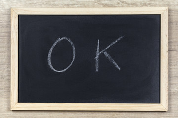 Space chalkboard background texture with wooden frame with the word "OK". blackboard space for wallpaper. Landscape mounting style horizontal.
