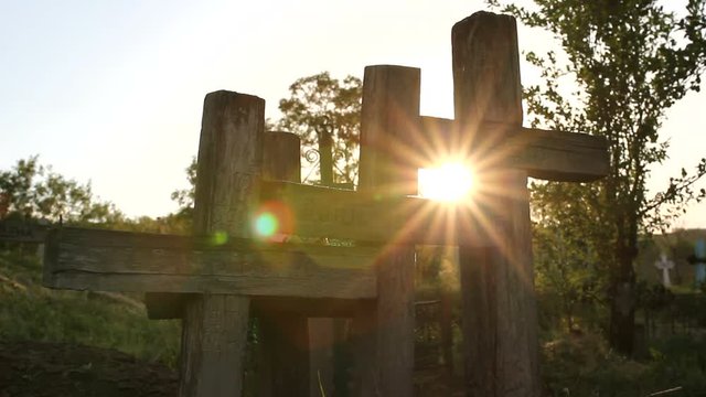 Shiny sun lighting in a graveyard between christian cross