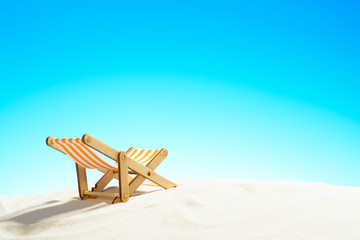 Sun lounger on the sandy beach and sky with copy space