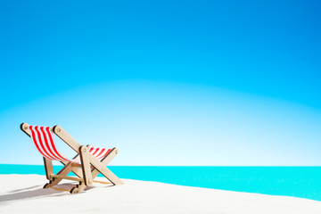 Sun lounger on the sandy beach by the sea and sky with copy space