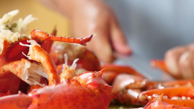 Hands chopping hot fresh boiled red lobster for dinner