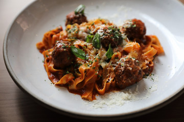 Spaghetti pasta with beef meatballs and tomato sauce on wood background . italian food
