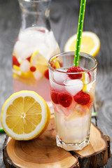 Fresh drink with raspberries, slices of lemon and the addition of ice