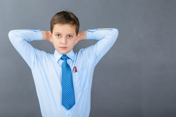 Confident boy student before dark background with copy-space as a blackboard