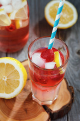 Glass of water with raspberries, slices of lemon and ice