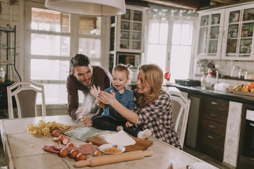 Happy family making pasta in the kitchen at home