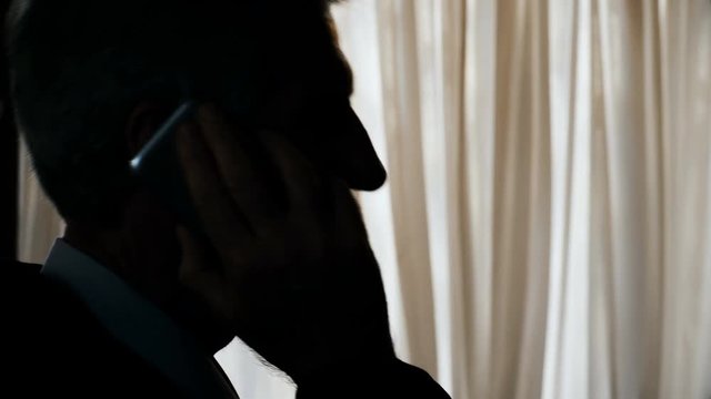 unrecognizable businessman talking by phonre in the dark- phone tapping 