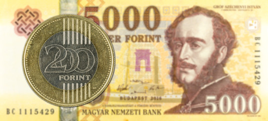 200 hungarian forint coin against 5000 hungarian forint bank note obverse
