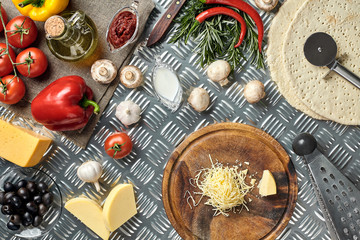 Cheese, different vegetables on metal table. Ingredients for traditional italian pizza.