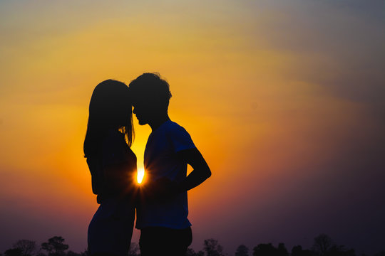 Silhouette couple lovers hugging at colorful sunset on background. Love concept.