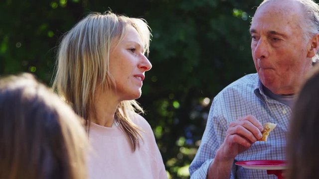 Middle aged woman and senior man talking at a block party