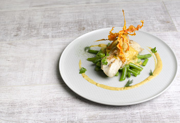 White fish baked with beans on a white plate