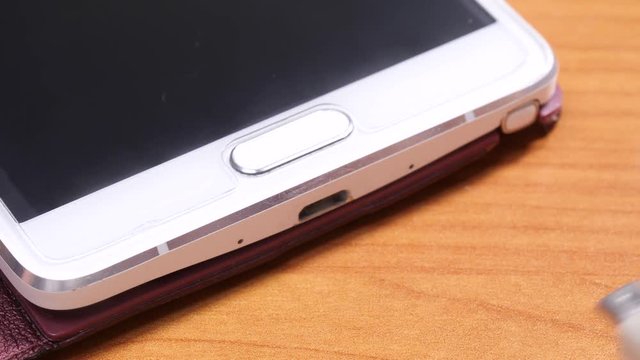 Close up mobile phone charging, male hand disconnecting unplug cable from smartphone