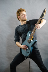 Young man playing electric guitar