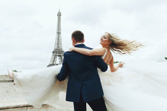 Lovely wedding couple poses before the Eiffel Tower in Paris