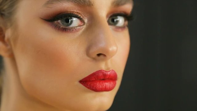 Portrait of a girl with an expressive look and red lipstick on her lips