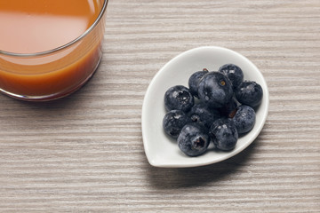 Fresh berries on a wooden table with a glass of juice. Antioxidants, detox diet, organic fruits.