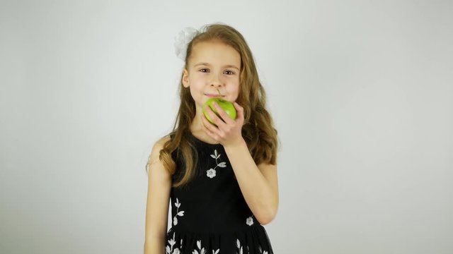 Smiling girl eats a green juicy apple and says Yum. Apple crunching when biting. Original sound