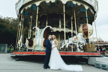 Classy wedding couple poses in the lunapark somewhere in Paris