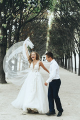 Naklejka premium Stunning newlyweds look luxury posing in classy dresses on the streets of romantic Paris