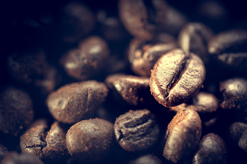 Grains of coffee lie on ground coffee. Unusual photo low key.