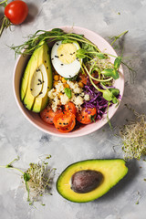 Healthy vegan lunch bowl. Vegan buddha bowl. Vegetables and nuts in buddha bowl on concrete background. Top view