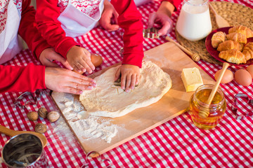 Process of cooking dessert. Children's and women's hands make figurines from the dough
