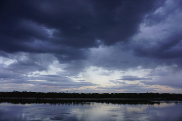 Landscape with forest and amazing sunset blue clouds reflected in river Dnieper, Kiev, Ukraine. 