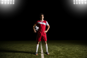 Male footballer in red with soccer ball