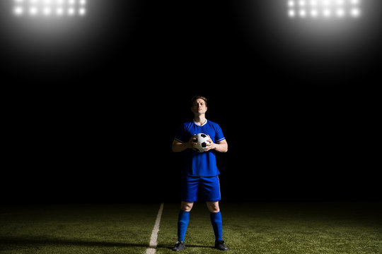 Male footballer in blue uniform on field