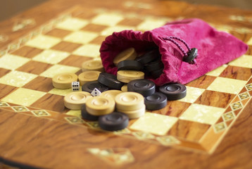      claret red case with dice and  black -and-white checkers on a chess board