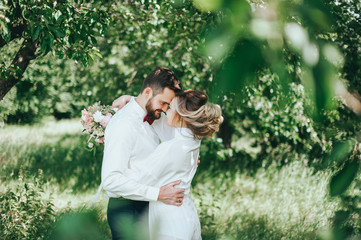 stylish groom with a beard and groom in the garden. fine art style. rustic