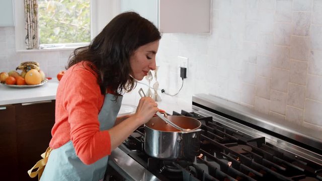 Woman cooking matzo ball soup in kitchen for Jewish passover