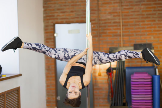 girl on a pole in the gym doing exercise