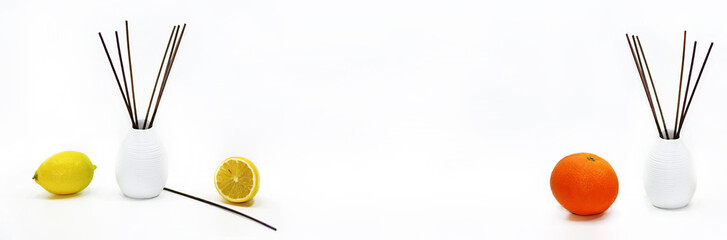 Aromatic sticks for home in white ceramic vase with fruits.