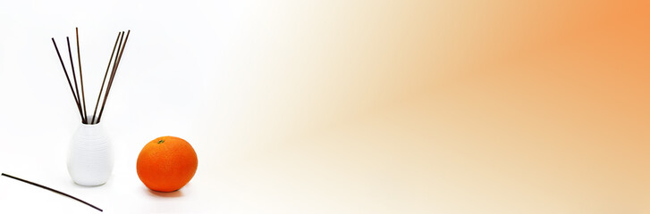 Aromatic sticks for home in white ceramic vase with fruits.