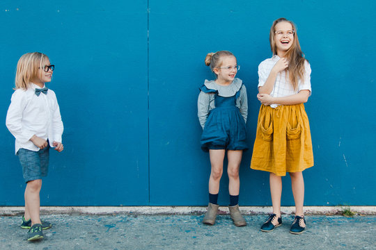 Children standing against blue wall