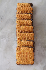 Square biscuits arranged in pattern on light textured background, close-up, shallow depth of field, selective focus.